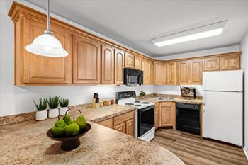 A kitchen with wooden cabinets and a granite countertop. at Malvern Hill Apartment Homes, 66103, KS